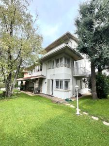 a large white house with a grass yard at Your Familyapartment in Sirmione in Sirmione