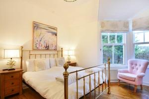 a bedroom with a bed and a chair and window at Periwinkle in Bamburgh
