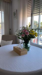 un jarrón de flores sentado sobre una mesa en Apartamento en Primera Linea, en La Herradura