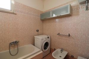 a bathroom with a washing machine and a sink at Elegant Holiday Home for 67 Guests in the Heart of Otranto in Otranto +43 photos