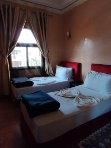 2 camas en una habitación con ventana en ApartHotel Nzaha, en Tahannout