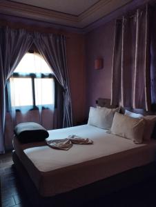 um quarto com uma cama grande e uma janela em ApartHotel Nzaha em Tahannout