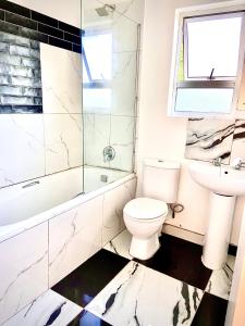 a bathroom with a toilet and a sink and a shower at The Beacon Fairy in East London