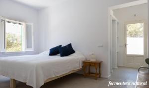 Casas Emma y Sofía - Porto Sale - Formentera Natural في سان فرانسيسكو خفير: غرفة نوم بيضاء بها سرير ونافذة