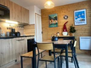eine Küche mit einem Tisch und Stühlen im Zimmer in der Unterkunft Mélèze B *** plein Sud in Chamrousse