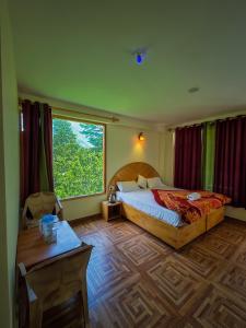 a bedroom with a bed and a large window at Uncle Nomad in Manāli