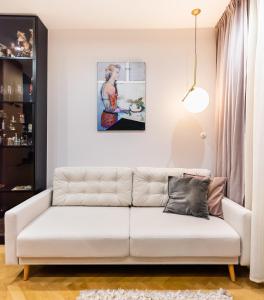 a white couch in a living room with a painting at MOSTOWA Abdank Old Town Apartment in Warsaw