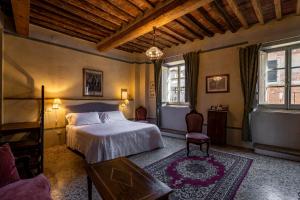 1 dormitorio con 1 cama y 1 mesa en Palazzo Mosela Alla Porta, en Montepulciano