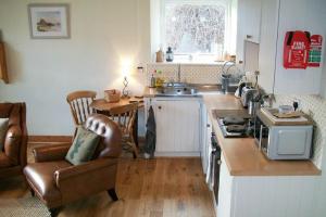a kitchen with a sink and a stove top oven at Swallow Cottage nr Powburn in Ingram