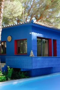 una casa azul con un árbol delante en El botanico de Sagra, en Sagra