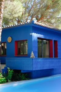 a blue house with a tree in front of it at El botanico de Sagra in Sagra