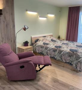 Un dormitorio con una silla púrpura y una cama en Kotsubinsky street LUX Apartment en Vínnytsia