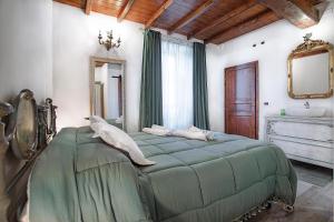 Un dormitorio con una gran cama verde y un lavabo. en Il Castagno, en Castiglione dei Pepoli