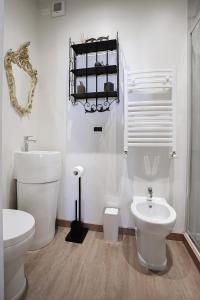 La salle de bains blanche est pourvue de toilettes et d'un lavabo. dans l'établissement Il Castagno, à Castiglione dei Pepoli