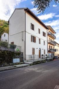 un bâtiment blanc sur le côté d'une rue dans l'établissement Il Castagno, à Castiglione dei Pepoli