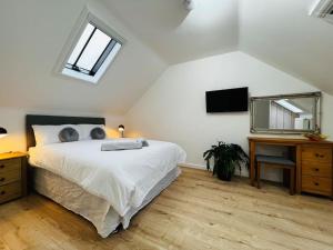 a bedroom with a bed and a desk and a television at Stable Cottage in Frome