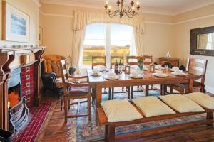a dining room with a table and a fireplace at The Villas No3 in Embleton