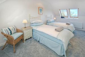 two beds in a room with a chair and a table at The Villas No3 in Embleton