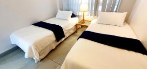 two beds in a room with a lamp on a table at Ramsgate Rendezvous 13 - Sleeps 6 - Great Sea Views! in Margate +8 photos