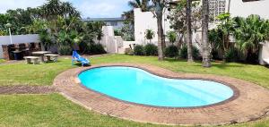 una piscina en un patio con una silla en el césped en Ramsgate Rendezvous 13 - Sleeps 6 - Great Sea Views!, en Margate