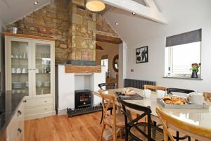 a kitchen and dining room with a table and a fireplace at The Hemmel Beadnell in Beadnell