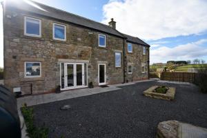 a large brick house with a courtyard in front of it at The Hemmel Beadnell in Beadnell