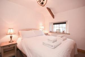 een slaapkamer met een wit bed en handdoeken bij Hares Form in Seahouses