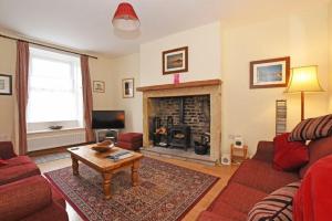 sala de estar con sofá y chimenea en Riverside Cottage en Warkworth