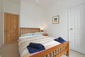 1 dormitorio con 1 cama con 2 toallas azules en Riverside Cottage en Warkworth