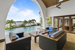 an outdoor patio with a table and chairs and a pool at Ocean-View Flamingo Palace with Stone Courtyard and Giant Infinity Pool in Playa Flamingo
