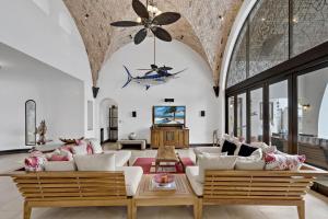 a living room with white furniture and a ceiling fan at Ocean-View Flamingo Palace with Stone Courtyard and Giant Infinity Pool in Playa Flamingo