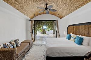a bedroom with a bed and a couch and a ceiling fan at Ocean-View Flamingo Palace with Stone Courtyard and Giant Infinity Pool in Playa Flamingo