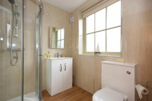 a bathroom with a shower and a toilet and a sink at Castle View Glororum in Bamburgh +15 photos