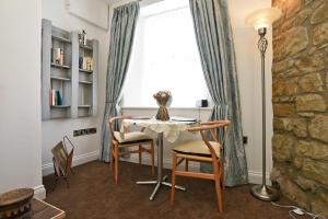 a dining room with a table and chairs and a window at Sea Air in Amble