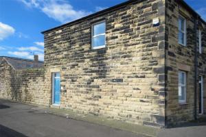 a brick building with two windows on a street at Sea Air in Amble
