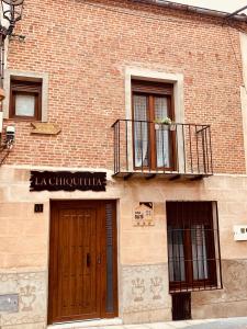 un edificio de ladrillo con puerta y balcón en Casa Rural La Chiquitita en Alaejos