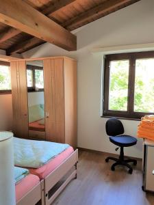 1 dormitorio con cama, escritorio y silla en "Vista Bellissima", en Brissago