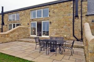 a patio with a table and chairs in front of a brick building at The Pepper Pot in Warkworth