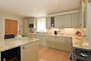 a large kitchen with white cabinets and granite counter tops at The Pepper Pot in Warkworth