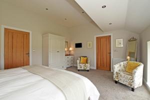 a bedroom with a large bed and two chairs at The Pepper Pot in Warkworth