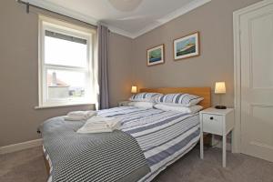 a bedroom with a bed and a window at Cladach Cottage in Seahouses