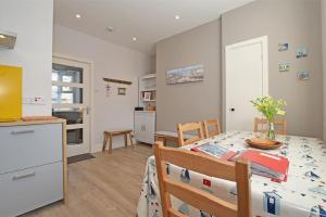 a kitchen and a dining room with a table and chairs at Cladach Cottage in Seahouses