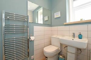 a bathroom with a toilet and a sink and a mirror at Cladach Cottage in Seahouses +11 photos