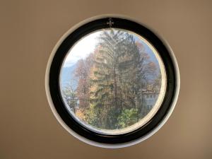 Una ventana redonda en una habitación con árboles en Villa Cavalli - Snozzi's Kunstwerk en Verscio