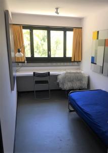 Schlafzimmer mit einem Bett, einem Schreibtisch und einem Fenster in der Unterkunft Villa Cavalli - Snozzi's Kunstwerk in Verscio
