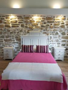 um quarto com uma cama grande e duas mesas de cabeceira em LA CASA DE LA HUERTA Stylish family cottage in Malaga countryside em Málaga