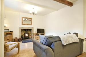 un soggiorno con divano e camino di West End Cottage a Embleton