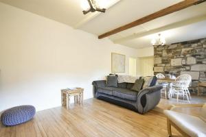 un soggiorno con divano e parete in pietra di West End Cottage a Embleton