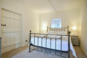 una camera con un letto e una finestra e una porta di West End Cottage a Embleton