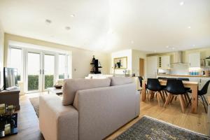 a living room with a couch and a kitchen at Rock Lodge in Alnmouth